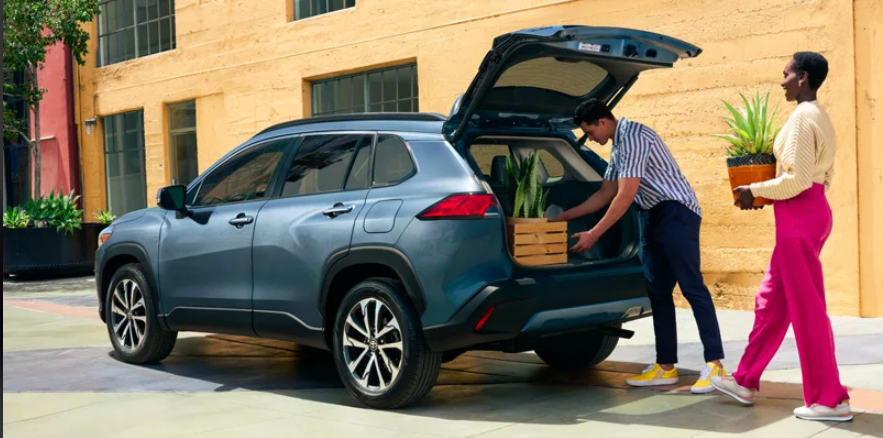 A man and a woman loading plants in to the back of a 2024 Toyota Corolla Cross.