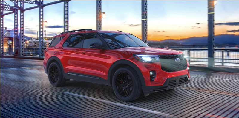 A red 2025 Ford Explorer crossing a large bridge with a sunset in the background.