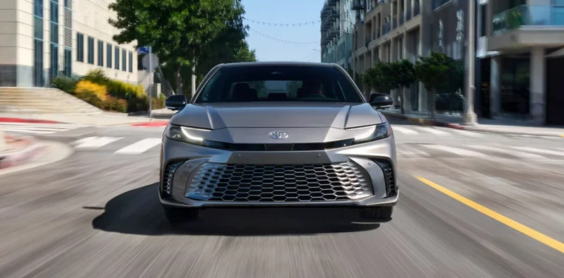 A photo of a silver 2026 Toyota Camry driving down the road.